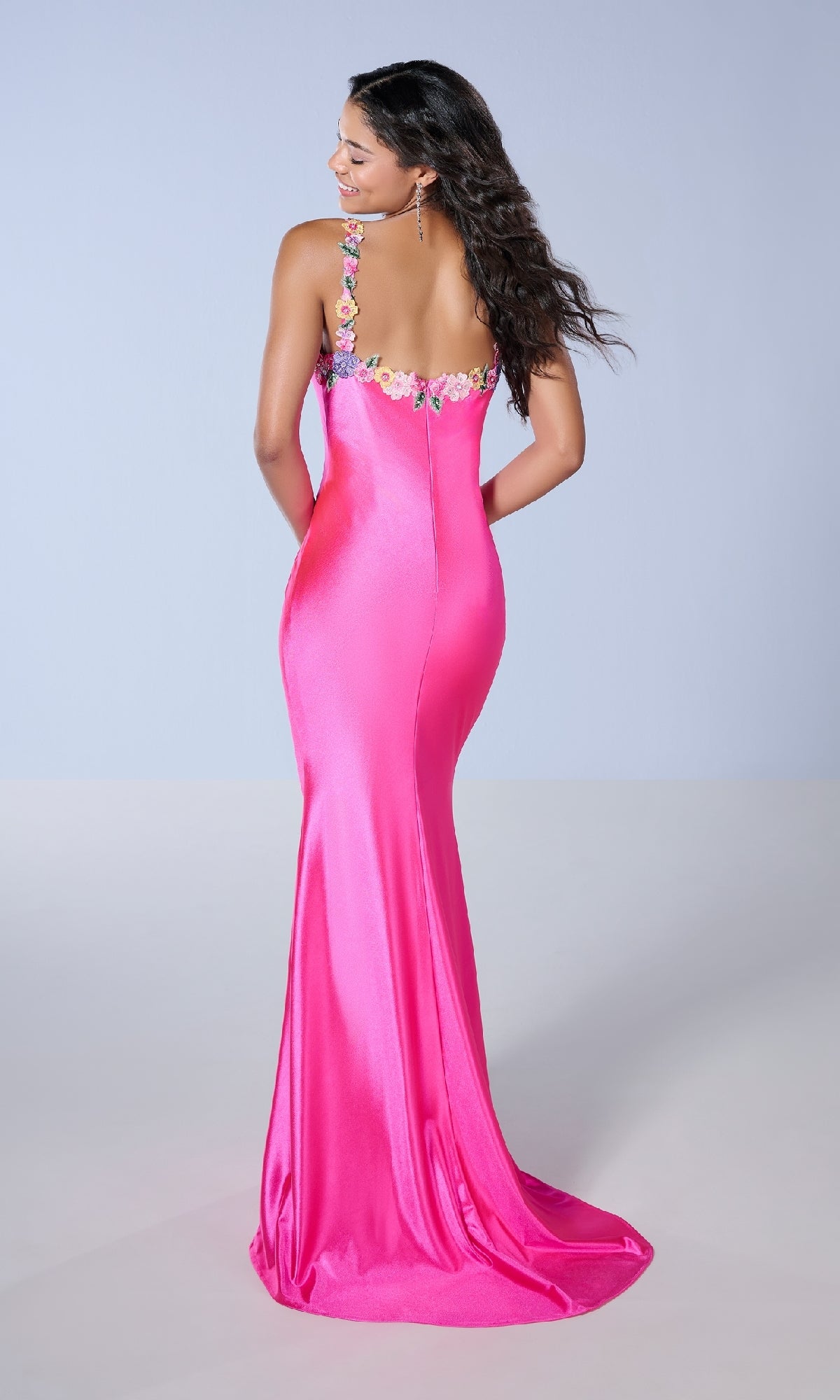 A woman is seen from behind wearing the Tiffany 16145 long prom dress in bright pink, featuring a slim fit and floral embroidery on the straps.